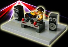 a lego man is sitting in front of some speakers and sound equipment on a table