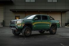 a green truck parked in front of a building