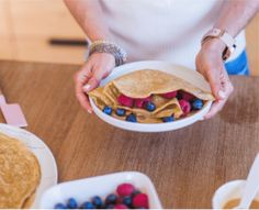 a person holding a plate with food on it and some fruit in the other hand