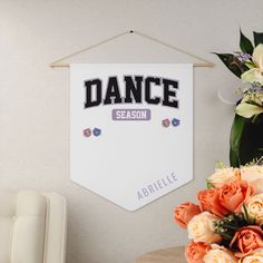 there is a sign that says dance on the wall next to flowers and a chair