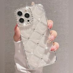 a woman's hand holding an iphone case with diamonds on it