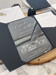 the inside of a black and white wedding suite on a table with napkins, rings and other items