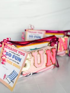 two pink and gold purses with thank you so fun tags on the front one has a sign that says,'thank you so fun this summer '