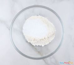 flour in a glass bowl on a marble counter top