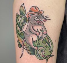 a rat with a hat and fish on his arm