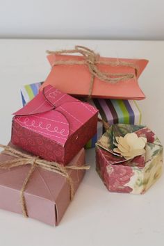 several boxes are stacked on top of each other and tied with twine, one is pink