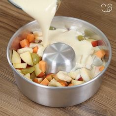 a person pouring dressing into a pot filled with vegetables