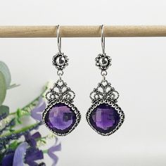 Handmade Artisan Crafted Filigree 925 Sterling Silver Earrings with Genuine Purple Amethyst Gemstones Material: 925 Solid Sterling Silver Amethyst Gemstones, 12 mm x 12 mm, Square, Faceted Earrings Length: 1.90 inches, Width: 0.65 inches Finishing: Oxidized and Polished Comes with a gift pouch and box Free Domestic Shipping Purple Earrings With Intricate Design For Gift, Purple Earrings With Intricate Design As Gift, Ornate Purple Sterling Silver Earrings, Silver Amethyst Crystal Earrings As Gift, Silver Amethyst Crystal Earrings For Gift, Ornate Gemstone Earrings In Sterling Silver, Ornate Sterling Silver Gemstone Earrings, Ornate Gemstone Earrings For Gifts, Sterling Silver Drop Crystal Earrings As Gift