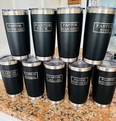 a group of black and silver cups sitting on top of a counter