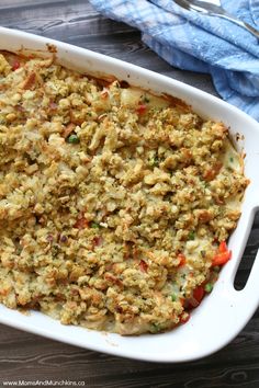 a casserole dish with meat and vegetables in it on a table next to a fork