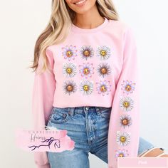 Introducing the sweatshirt that will make you the reigning champion of cozy comfort and cute style - our Daisy Happy Face Graphic Tic Tac Toe Sweatshirt! This sweatshirt is perfect for anyone who loves a good game of tic tac toe, and wants to show off their sunny personality while doing it. Made from high-quality Gildan 18000 fabric, this sweatshirt is soft, warm, and comfortable to wear all day long. The print on the front and down both sleeves features a cheerful daisy happy face design, sure Pink Crew Top For Spring, Pink Crew Neck Top For Spring, Pink Crew Sweatshirt For Spring, Pink Crew Neck Sweatshirt For Spring, Pink Cotton Sweatshirt With Custom Print, Pink Casual Sweatshirt With Custom Print, Pink Relaxed Fit Sweatshirt For Spring, Spring Cotton Sweatshirt With Custom Print, Pink Long Sleeve T-shirt With Custom Print