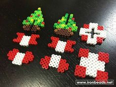 several pieces of bead art are arranged on a black surface, including one christmas tree