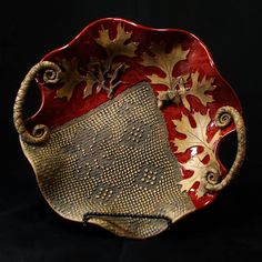 a red and gold plate with leaves on it