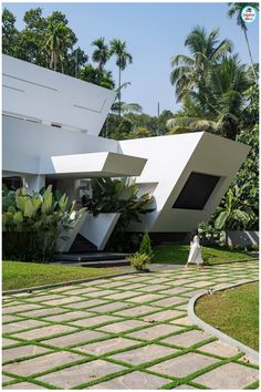 a woman walking down a walkway in front of a white building