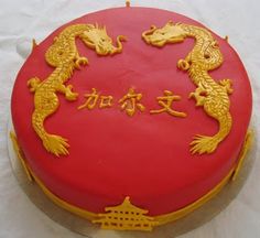 a red cake with gold dragon decorations on it's side and chinese writing in the middle