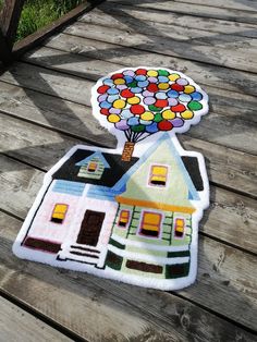 a house with a tree on top of it is sitting on a wooden deck outside