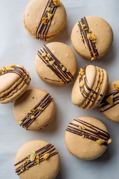 several cookies with chocolate frosting and gold decorations on them are arranged in a circle