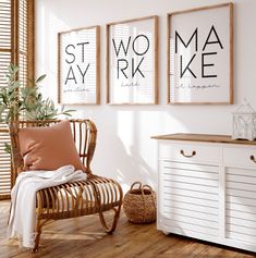 a white room with three framed posters on the wall and a wicker chair next to it