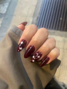 dark red nails almond with white stars December Nail Ideas Almond Shape, Red Winter Nails Almond, Short Almond Star Nails, Sza Nails Inspired, Red Nails Pattern, Dark Red Nails With Flowers, Almond Nail Ideas Fall, Cute Dark Red Nails