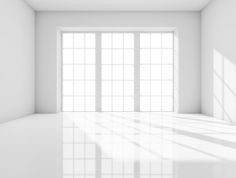 an empty room with white walls and windows