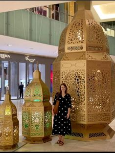 a woman is standing next to some decorative lanterns