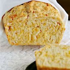 a loaf of bread sitting on top of a white towel next to a slice of bread