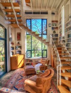 a living room filled with furniture and a spiral staircase leading up to the second floor