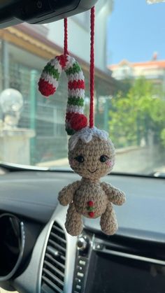 a crocheted stuffed animal hanging from a car dash board