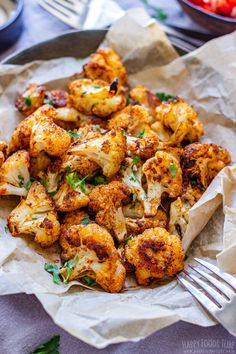 roasted cauliflower with parsley on top in a bowl next to a fork