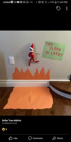 an elf is on the floor in front of a sign