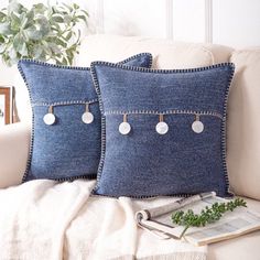 two blue denim pillows on a white couch