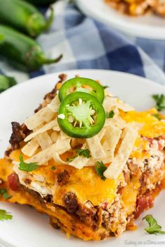 a slice of mexican casserole on a white plate with green peppers and cheese