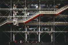 people are walking on scaffolding in front of a building with an escalator