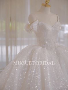 a white wedding dress on display in front of a window