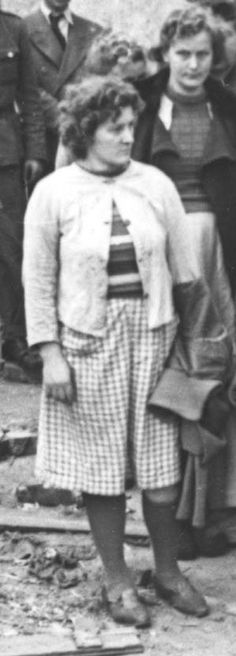 an old black and white photo of a woman standing in front of other people with hats on