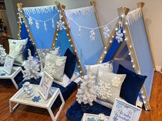 several blue and white pillows on display in front of a christmas tree with snowflakes