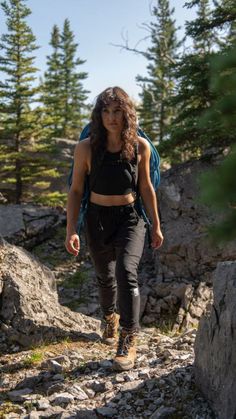 a woman hiking up a rocky trail in the mountains