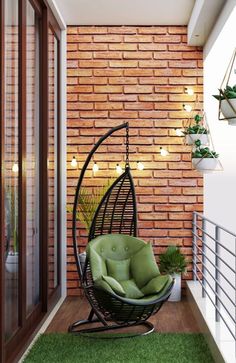 a green chair sitting on top of a grass covered floor next to a brick wall