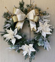 a christmas wreath hanging on a door with snowflakes and gold bowknots