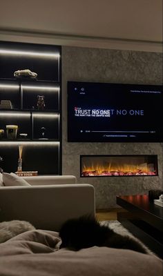 a living room filled with furniture and a flat screen tv mounted on the wall next to a fire place