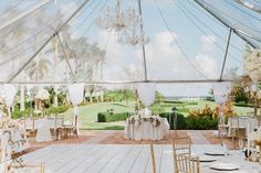 the inside of a tent with tables and chairs set up for a formal dinner party