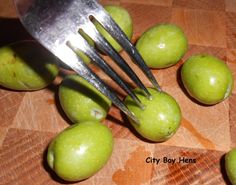 green apples being cut by a fork on a cutting board with the words city boy hens underneath it