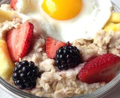 an oatmeal dish with berries, strawberries and eggs