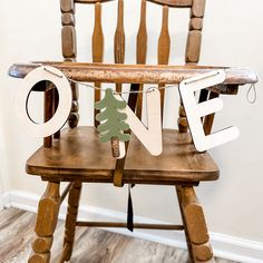 a wooden chair with a christmas tree on it and the word love spelled out in large letters