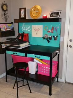 a desk with some pink and blue bins on it's shelf next to a white door