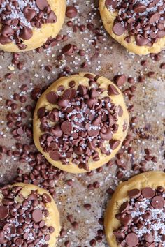 cookies with chocolate chips and sprinkles on a baking sheet covered in powdered sugar