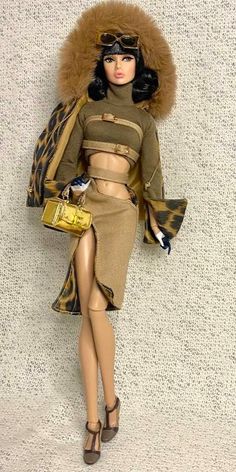 a barbie doll wearing a brown outfit and leopard print coat with fur on the top