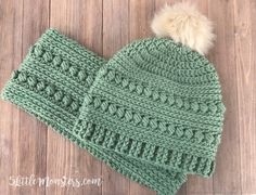 a green knitted hat with a pom - pom on top