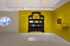 a room with yellow walls and white floors has a book case on the wall next to it