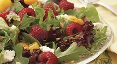 a salad with raspberries and goat cheese